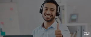 Hombre adulto joven con barba feliz, dentro de un call center, close up, haciendo pulgar arriba
